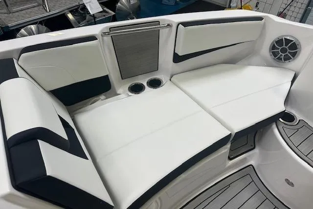 Slide: The Image of 2025 Yamaha Boats 222SE interior seating with white and black upholstery, cup holders, and speaker. - 20