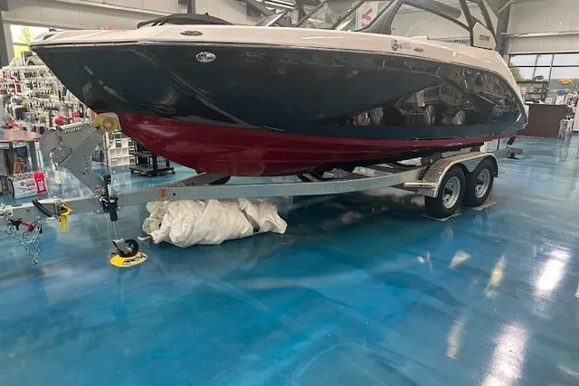 Slide: The Image of 2025 Yamaha Boats 222SE on trailer in showroom with blue floor. - 5