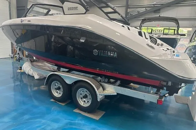 Slide: The Image of 2025 Yamaha Boats 222SE on trailer in showroom, side view. - 7