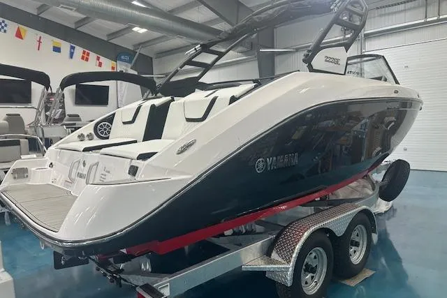 Slide: The Image of 2025 Yamaha Boats 222SE on trailer in showroom, sleek design, dual engines visible. - 8