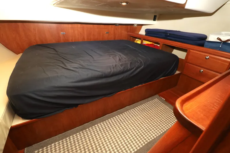 Slide: The Image of Cozy cabin interior of 2011 Hunter 39 sailboat with wooden furnishings and a comfortable bed. - 12