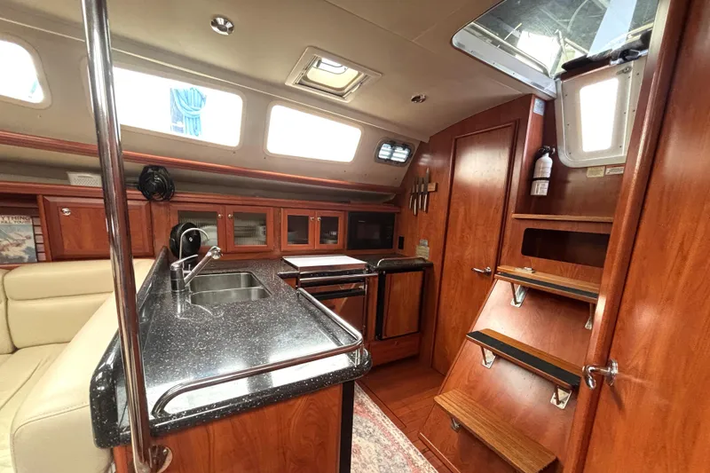 Slide: The Image of Luxurious interior of 2011 Hunter 39 yacht featuring modern kitchen and wooden cabinetry. - 16