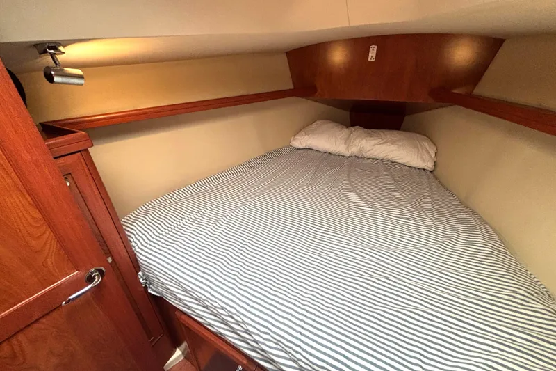 Slide: The Image of Cozy cabin interior of 2011 Hunter 39 sailboat with striped bedding and wooden accents. - 19