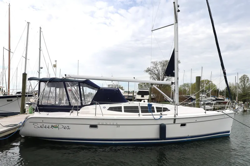 Slide: The Image of 2011 Hunter 39 sailboat docked at marina, featuring sleek design and spacious cockpit. - 37