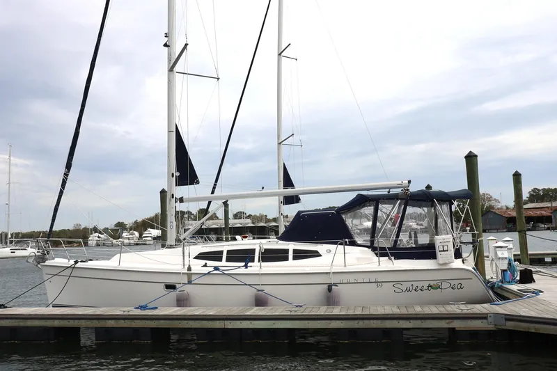 Slide: The Image of 2011 Hunter 39 sailboat docked at marina, featuring sleek design and spacious cockpit. - 38