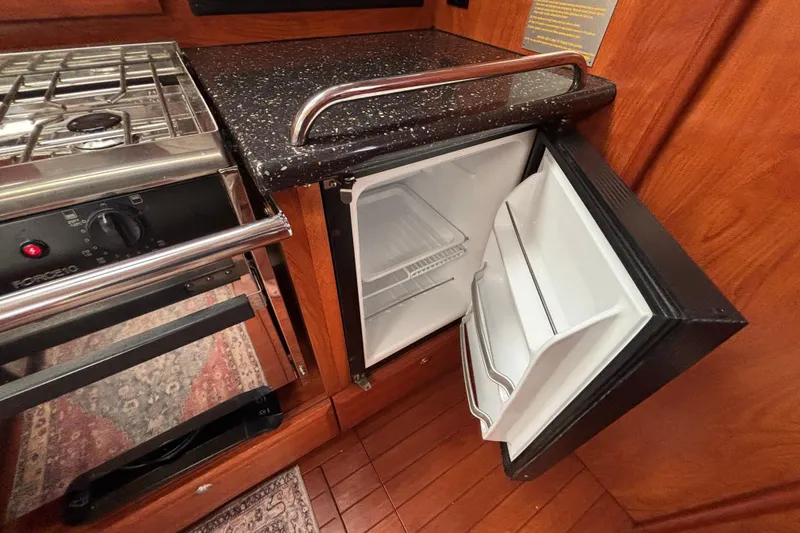 Slide: The Image of Compact kitchen area in a 2011 Hunter 39 yacht with stove and open fridge. - 7