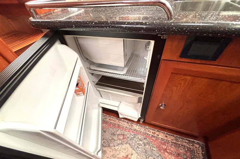 Slide: The Image of Open refrigerator in a 2011 Hunter 39 yacht kitchen with wooden cabinetry. - 8