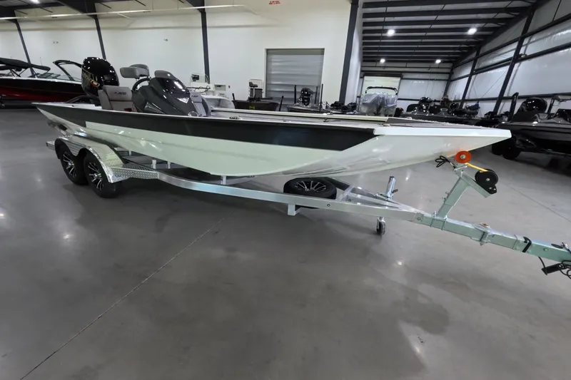 The Image of 2026 Avid 20 Vertex boat on trailer in showroom, featuring sleek design and modern outboard motor. - 1