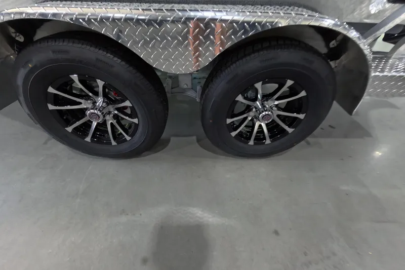 Slide: The Image of 2026 Avid 20 Vertex trailer wheels with sleek black and silver rims on concrete floor. - 14