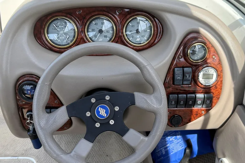 Slide: The Image of Dashboard of a 2003 Four Winns 210 Horizon boat with steering wheel and gauges. - 10