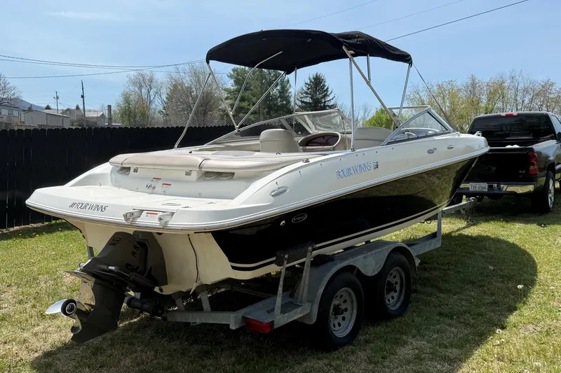 Slide: The Image of 2003 Four Winns 210 Horizon boat on trailer, parked on grass, with black canopy. - 11
