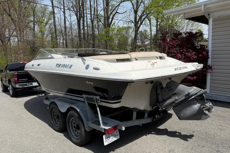 Slide: The Image of 2003 Four Winns 210 Horizon boat on trailer, parked outdoors near trees. - 3