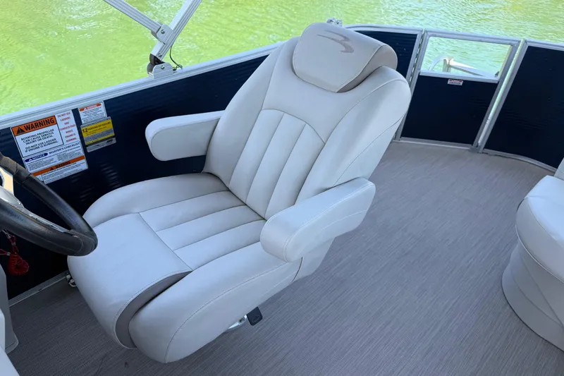 Slide: The Image of Captain's chair on 2017 Bennington 21 SLX pontoon boat, featuring plush white upholstery. - 15