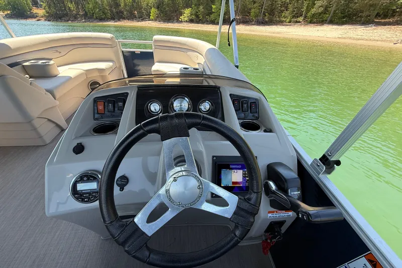 Slide: The Image of Cockpit view of 2017 Bennington 21 SLX pontoon boat on a serene lake. - 22
