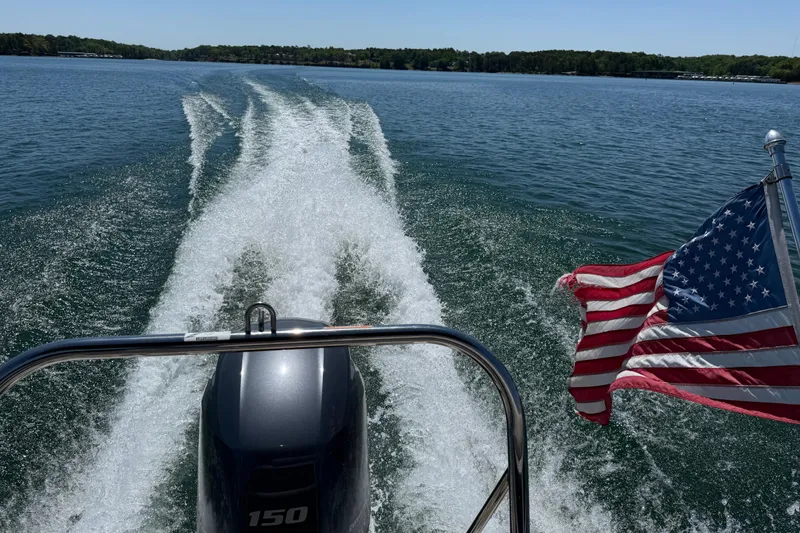Slide: The Image of 2017 Bennington 21 SLX boat cruising on a lake with American flag waving. - 38