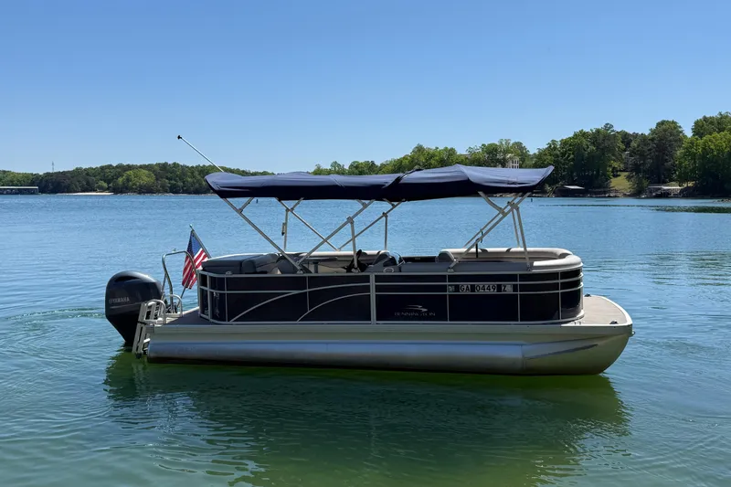 Slide: The Image of 2017 Bennington 21 SLX pontoon boat on a serene lake with clear blue skies. - 4