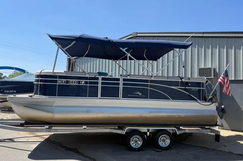 Slide: The Image of 2017 Bennington 21 SLX pontoon boat with canopy on trailer, parked outdoors. - 40