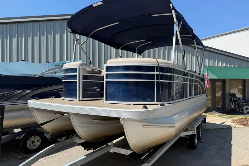Slide: The Image of 2017 Bennington 21 SLX pontoon boat with canopy on trailer, parked outside a building. - 41