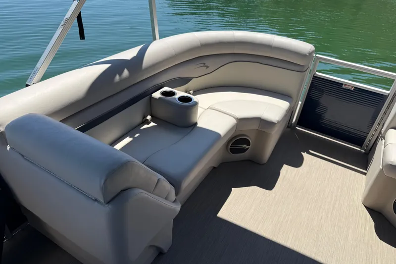 Slide: The Image of 2017 Bennington 21 SLX pontoon boat interior with plush seating and cup holders on a sunny day. - 9