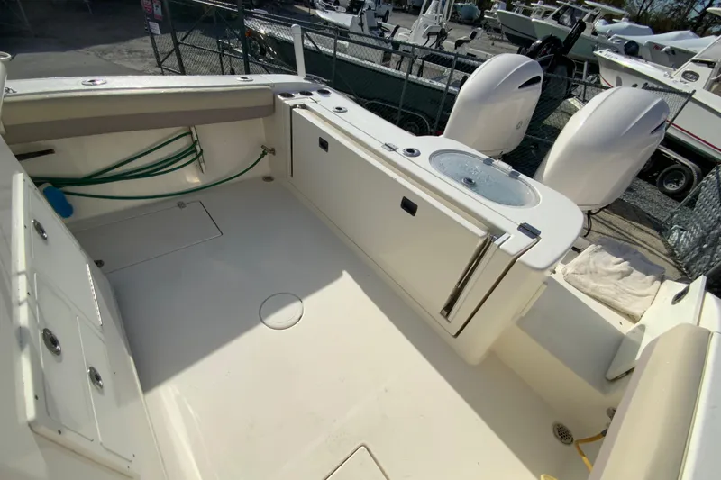 Slide: The Image of 2017 Cobia 277 Center Console boat interior with storage and dual engines. - 12