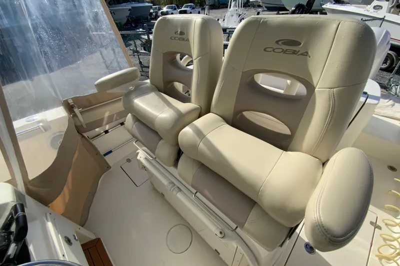Slide: The Image of 2017 Cobia 277 Center Console boat with beige cushioned seats and armrests. - 14