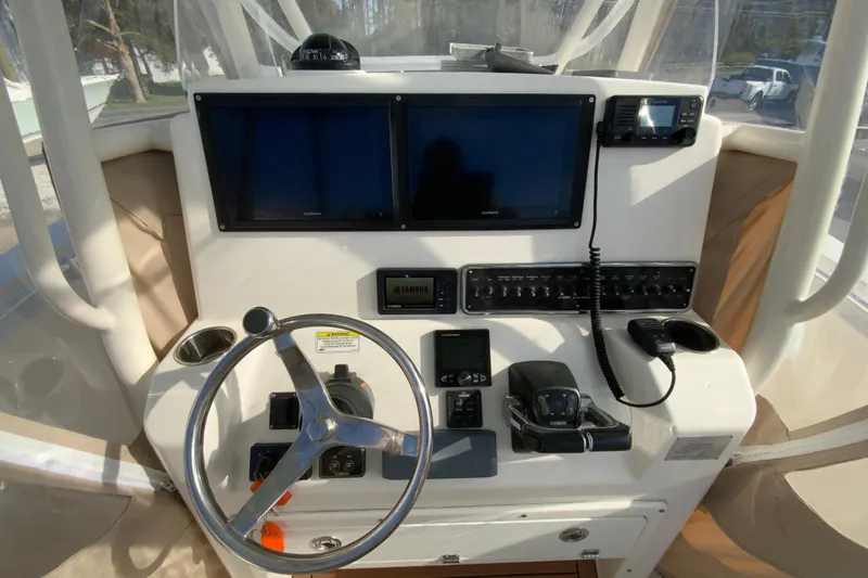 Slide: The Image of 2017 Cobia 277 Center Console boat dashboard with steering wheel and electronic controls. - 16