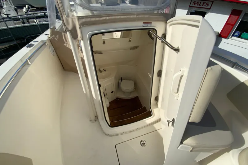 Slide: The Image of 2017 Cobia 277 Center Console boat interior with open door to compact bathroom. - 26
