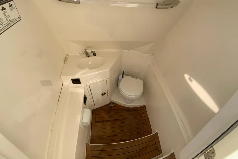 Slide: The Image of 2017 Cobia 277 Center Console boat bathroom with wooden flooring and compact design. - 27