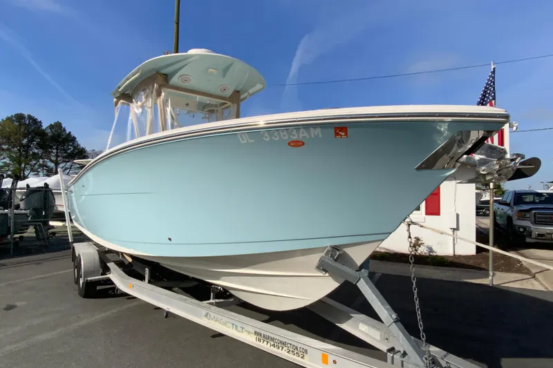 Slide: The Image of 2017 Cobia 277 Center Console boat on trailer, light blue hull, sunny day. - 3