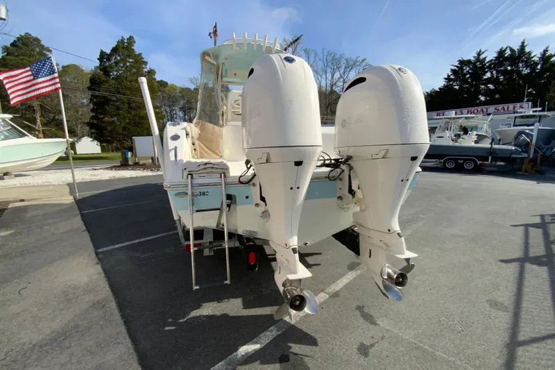 Slide: The Image of 2017 Cobia 277 Center Console boat with dual outboard engines in a marina setting. - 8