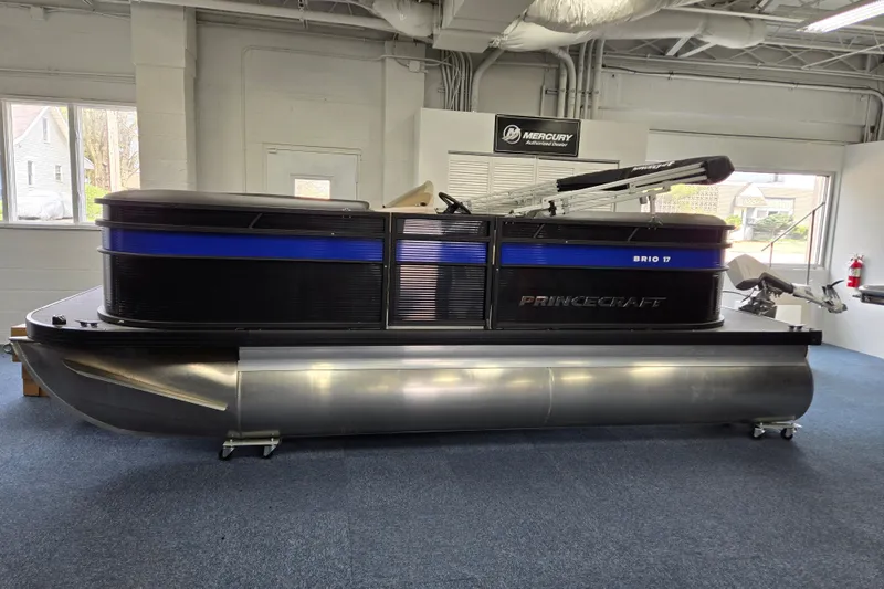 Slide: The Image of 2026 Princecraft Brio 17 Electric pontoon boat displayed indoors. - 2
