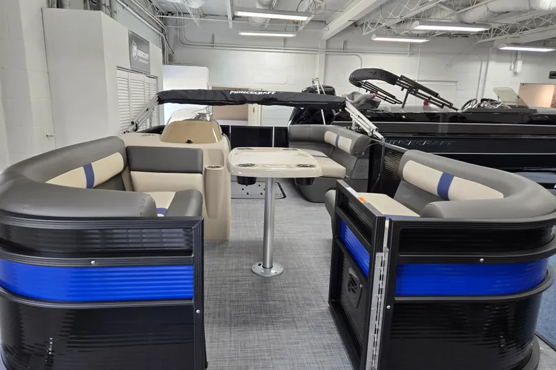 Slide: The Image of 2026 Princecraft Brio 17 Electric pontoon boat interior with seating and table in showroom. - 3