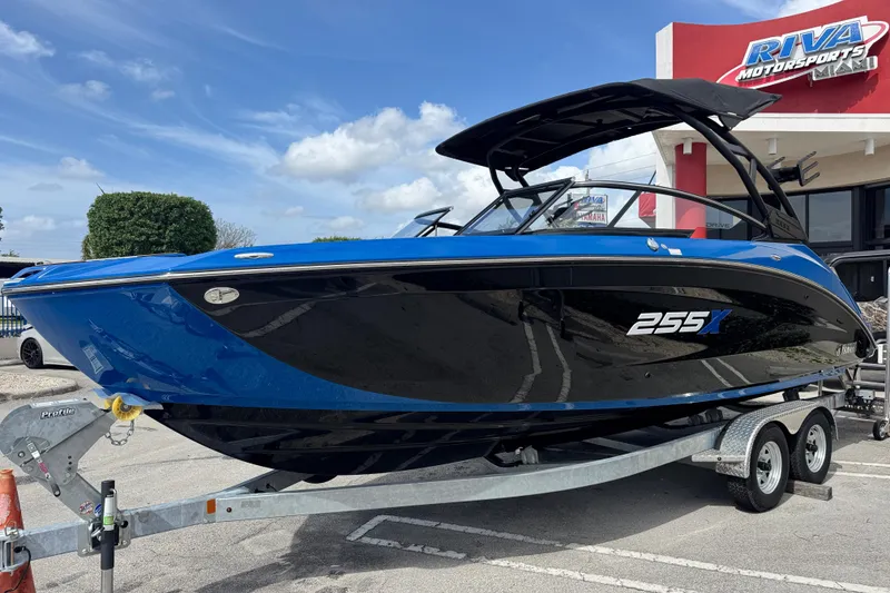 Slide: The Image of 2026 Yamaha Boats 255XD in blue and black on a trailer at Riva Motorsports. - 2