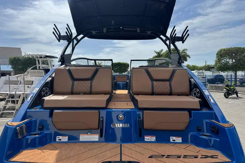 Slide: The Image of 2026 Yamaha Boats 255XD, blue exterior, luxurious seating, docked under clear sky. - 4