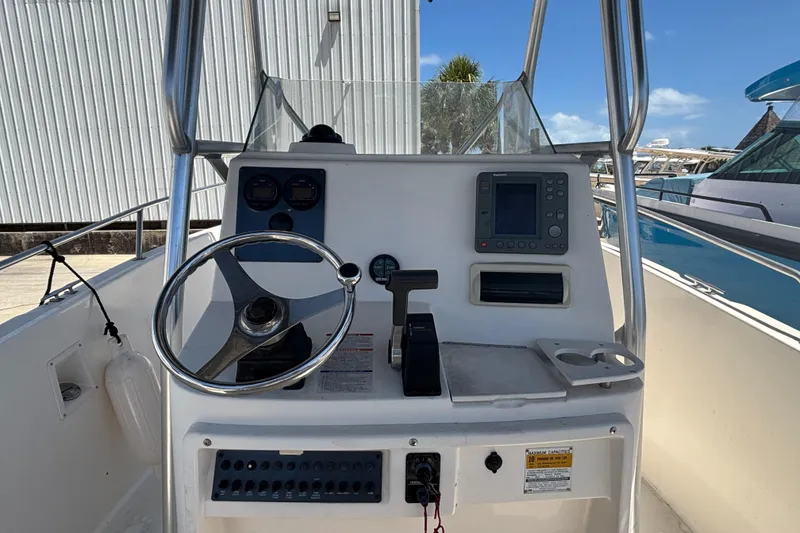 Slide: The Image of 2003 Robalo R230 Center Console boat dashboard with steering wheel and navigation controls. - 7