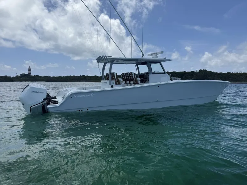 Slide: The Image of 2026 Freeman 38 boat on water with Mercury engine, lighthouse in background. - 3