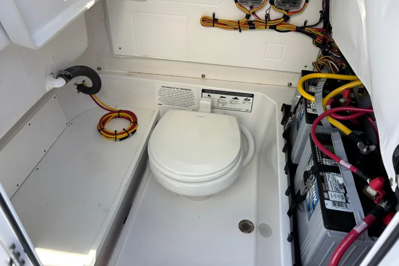 Slide: The Image of 2025 Sportsman Heritage 231 Center Console boat interior with toilet and battery compartment. - 14