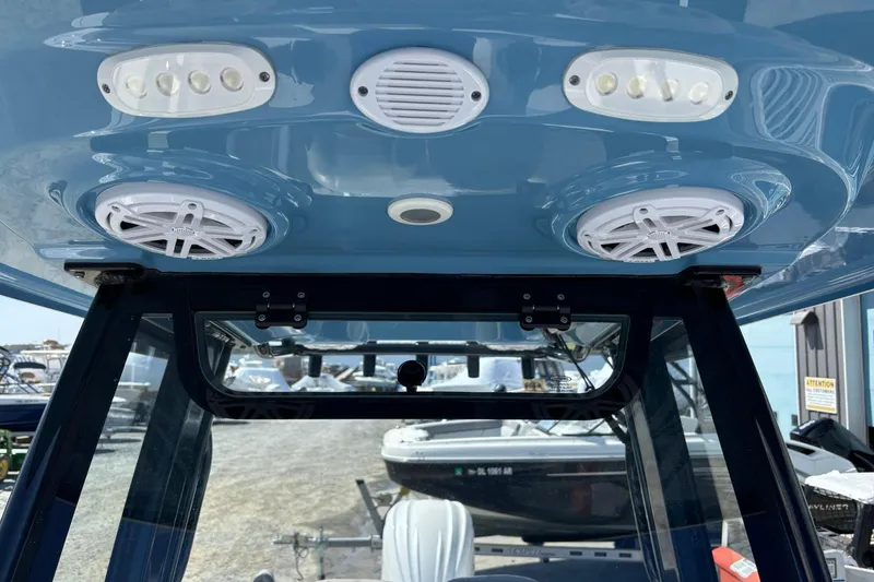 Slide: The Image of 2025 Sportsman Heritage 231 Center Console boat speakers and lights on blue ceiling. - 16