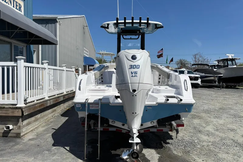 Slide: The Image of 2025 Sportsman Heritage 231 Center Console boat with Yamaha 300 V6 engine displayed outdoors. - 2