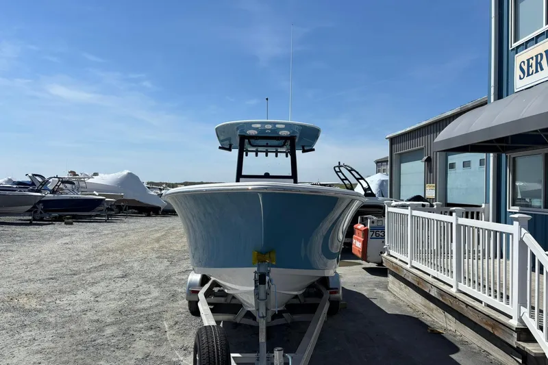 Slide: The Image of 2025 Sportsman Heritage 231 Center Console boat on trailer, parked near service building. - 3