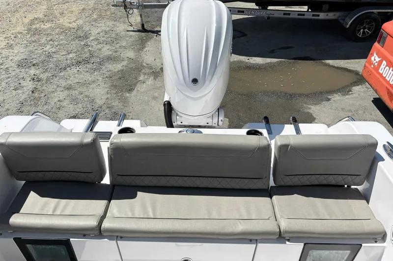 Slide: The Image of 2025 Sportsman Heritage 231 Center Console boat with cushioned seating and outboard motor. - 4