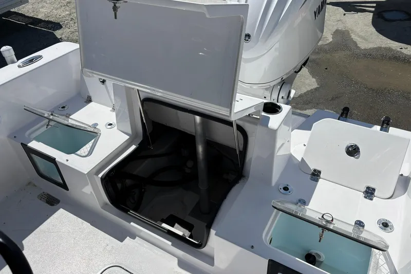 Slide: The Image of 2025 Sportsman Heritage 231 Center Console boat interior with open compartments and engine view. - 5