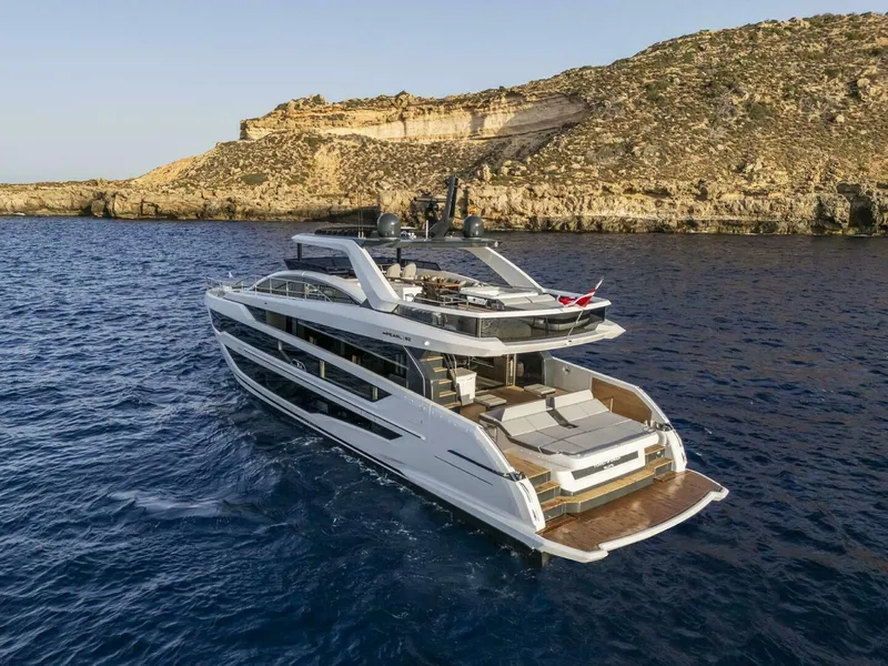 Slide: The Image of Luxurious 2026 Pearl 82 yacht cruising near rocky coastline in clear blue waters. - 4