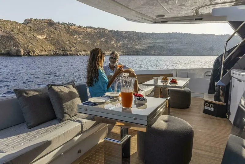 Slide: The Image of Couple enjoying drinks on a luxurious 2026 Pearl 82 yacht with scenic ocean view. - 7