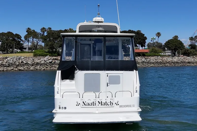 Slide: The Image of 2007 Carver 43 Motor Yacht on water, rear view with "Nauti Match" name. - 11