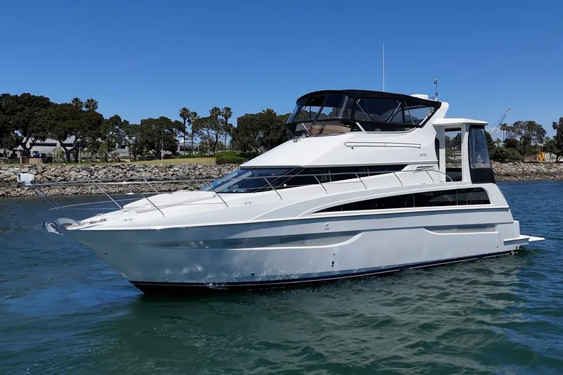 Slide: The Image of 2007 Carver 43 Motor Yacht cruising on a sunny day near a rocky shoreline. - 3