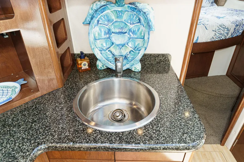 Slide: The Image of Luxury yacht kitchen sink with granite countertop, decorative turtle, and wooden cabinetry in 2007 Carver 43 Motor Yacht. - 42