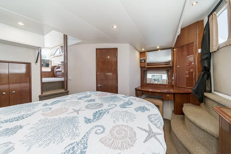 Slide: The Image of Luxurious interior of 2007 Carver 43 Motor Yacht with elegant wood finishes and cozy bedding. - 53