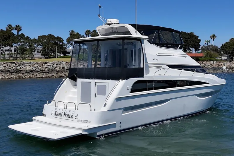 Slide: The Image of 2007 Carver 43 Motor Yacht cruising on a sunny day near rocky shoreline. - 6