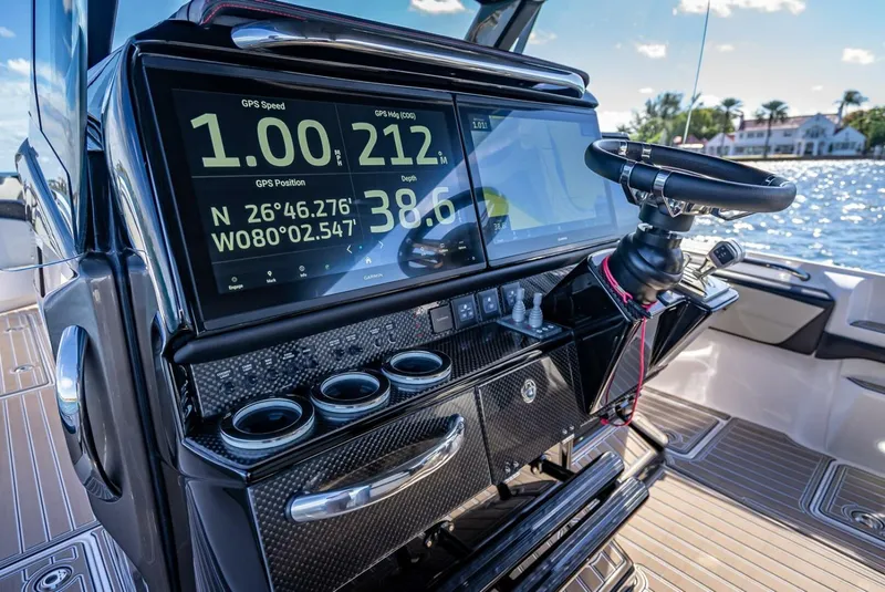 Slide: The Image of 2023 Nor-Tech 500 Sport boat dashboard with GPS display and steering wheel. - 15